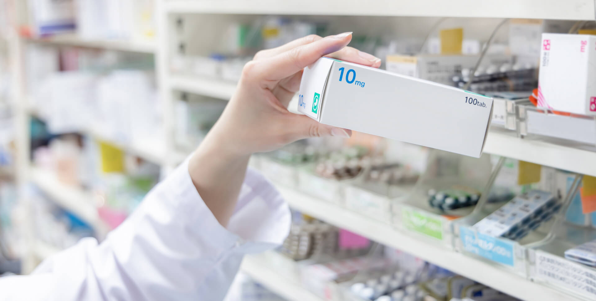 薬の箱を持つ薬剤師